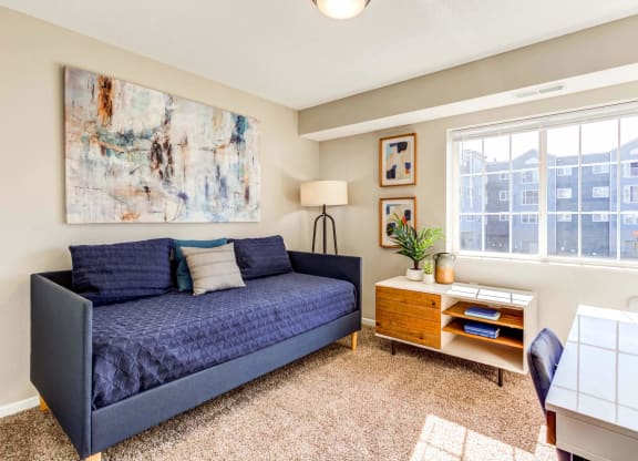 a living room with a couch and a desk
