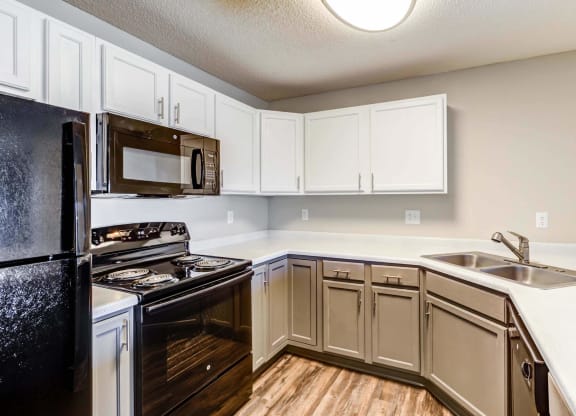 a kitchen with white cabinets and black appliances