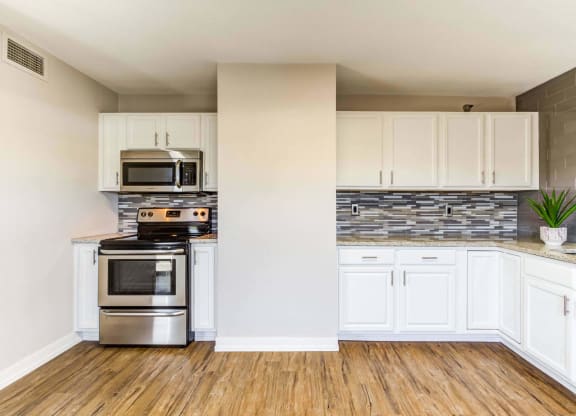 a kitchen with white cabinets and stainless steel appliances