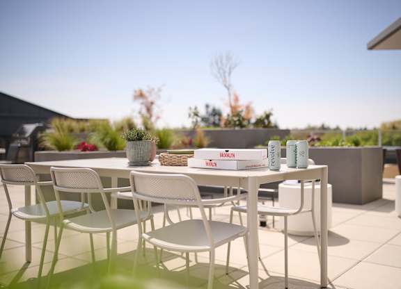 A white table and chairs are set up on a patio.