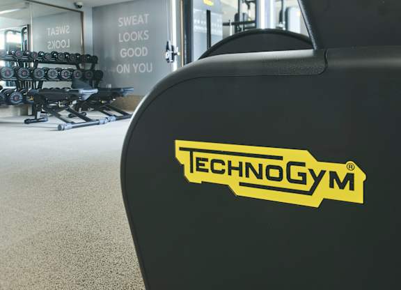A close up of a black Technogym machine in a gym.