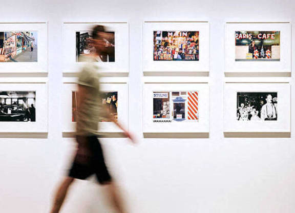 a person walking past pictures on a wall