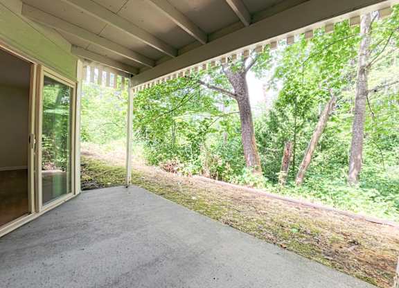 A patio with a view of trees and grass.