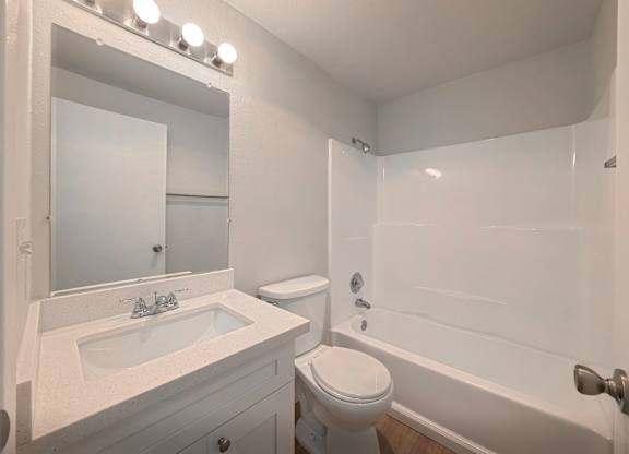 A white bathroom with a sink, toilet, and bathtub.