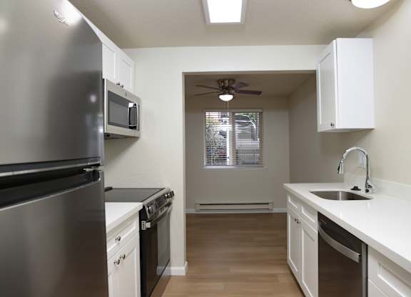A kitchen with a stainless steel refrigerator and black oven.