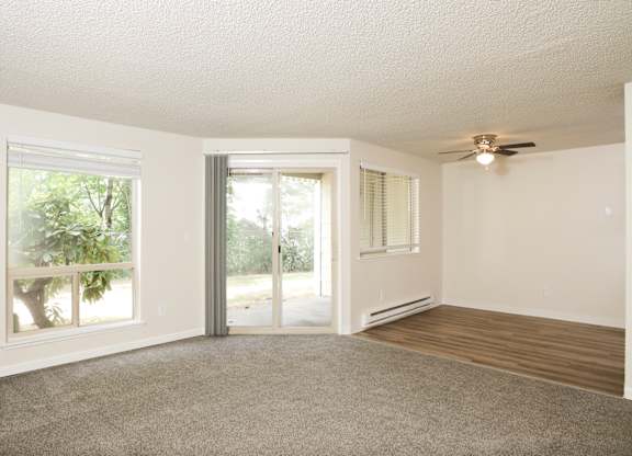 A room with a sliding glass door and a ceiling fan.