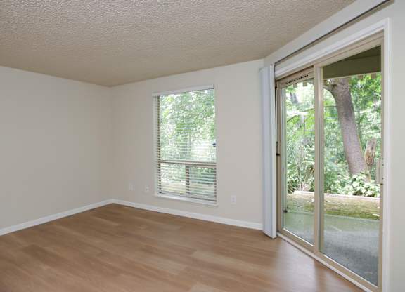 A room with a sliding glass door leading to a backyard.