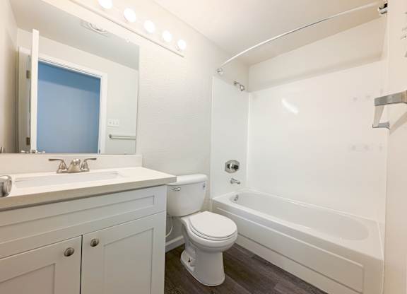 A white bathroom with a toilet, sink, and bathtub.