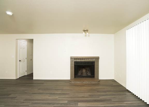 A room with a fireplace and wooden floors.