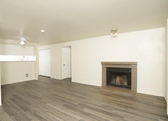 A living room with a fireplace and wood flooring.