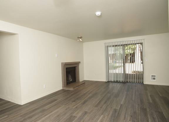 A room with a fireplace and wooden floors.