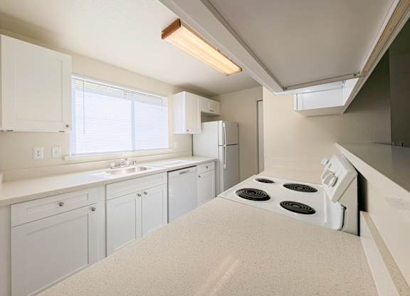 A kitchen with white appliances and cabinets.