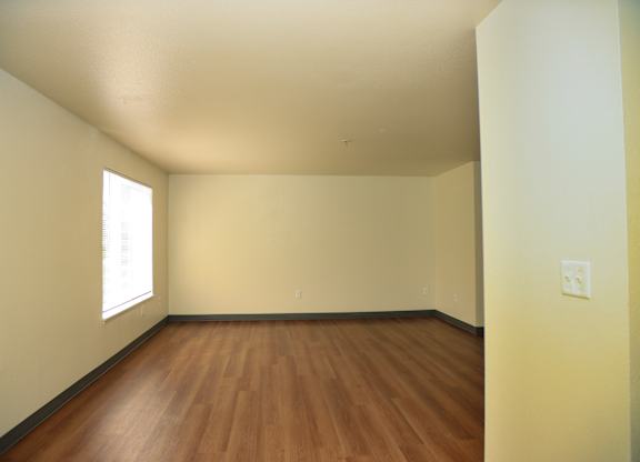 Empty room with wooden floor and white walls.