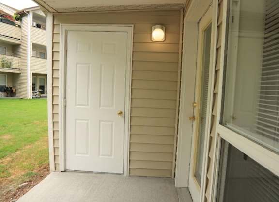 A white door is on the left side of a house.