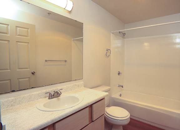 A white bathroom with a toilet, sink, and bathtub.