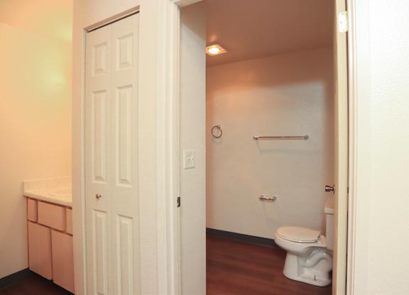A white door is open to a small bathroom with a toilet.