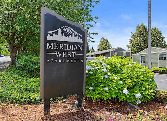 A sign for Meridian West Apartments is shown in front of a building.