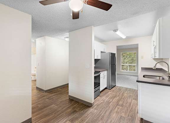 A kitchen with a refrigerator, sink, and oven.