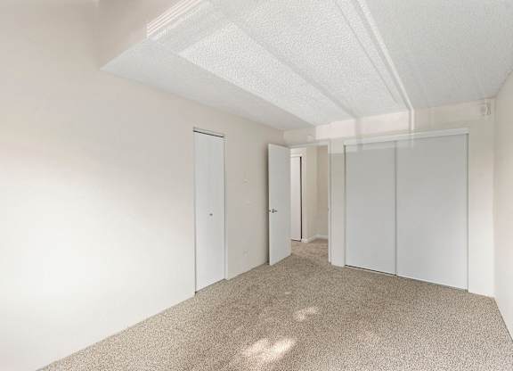 A white room with carpeted floor and white walls.