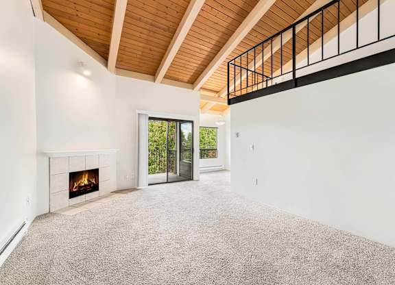 A room with a fireplace and a carpeted floor.