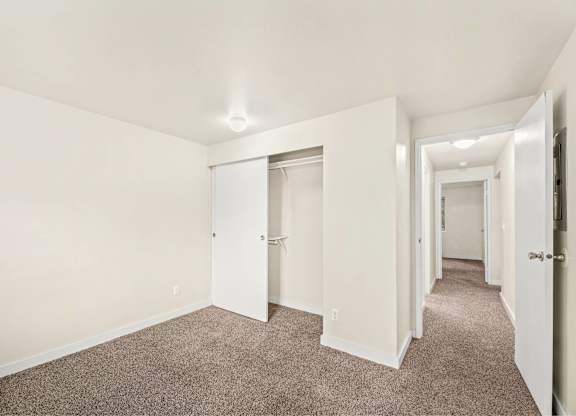 A long hallway with carpeted floors and white walls.