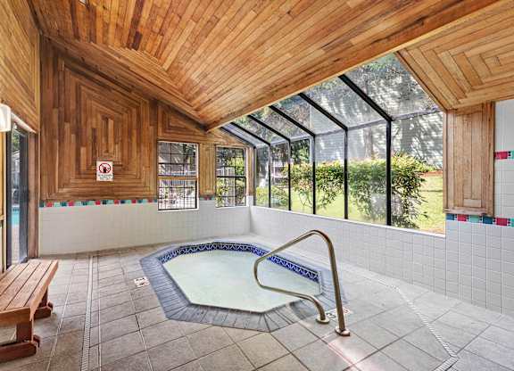 A wooden ceiling over a hot tub in a room.