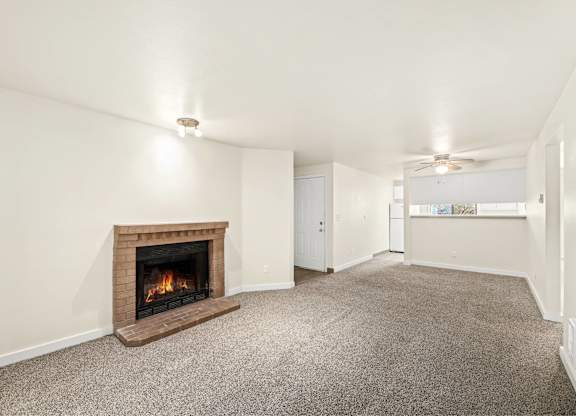 A room with a fireplace and carpeted floor.