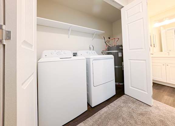 A white washing machine and dryer in a small laundry room.