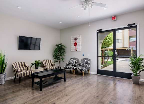 A living room with a black table and striped chairs.