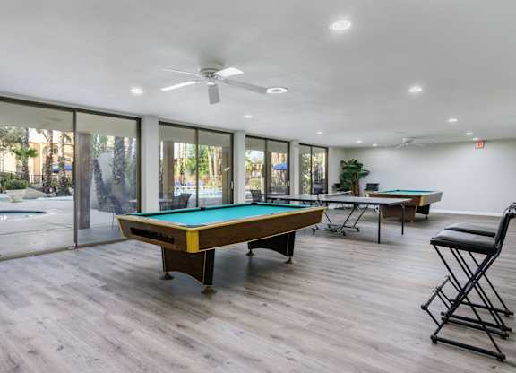 A room with a pool table and a chair.