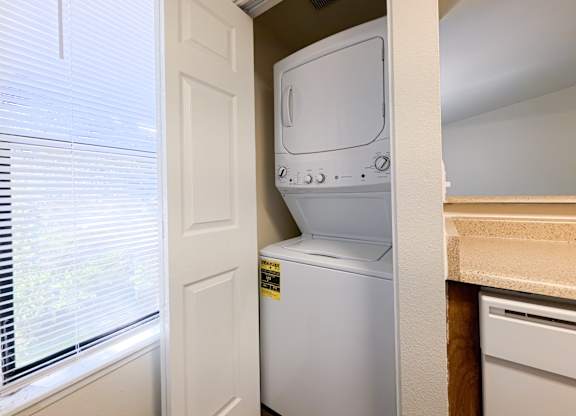 A white dishwasher is in a small kitchen.