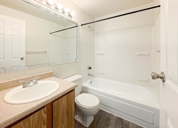 A white bathroom with a sink, toilet, and bathtub.