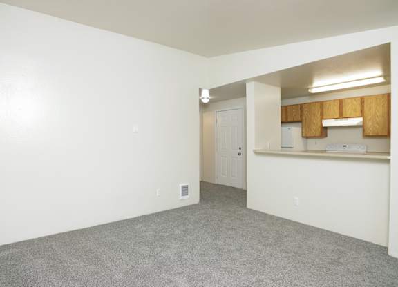 A room with white walls and a grey carpet.