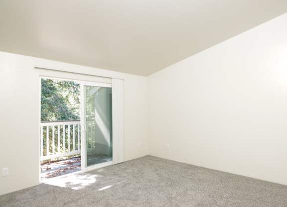 A room with a sliding glass door leading to a deck.