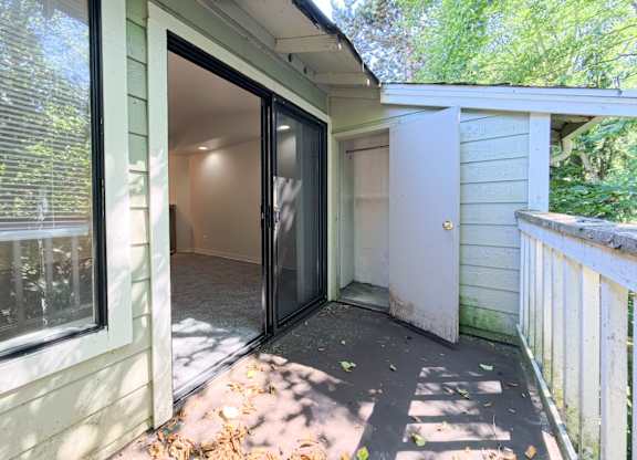 A sunny day with a patio and a sliding glass door.