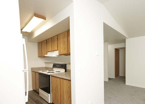 A kitchen with wooden cabinets and a stove top oven.