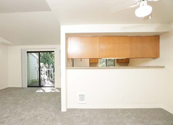 A room with a window and a ceiling fan.