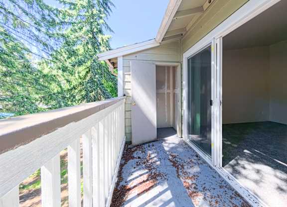 A sunny day with a white fence and a glass door.