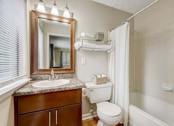 A bathroom with a toilet, sink, and shower.