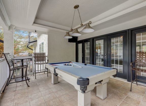 a pool table in the porch of a house with a patio