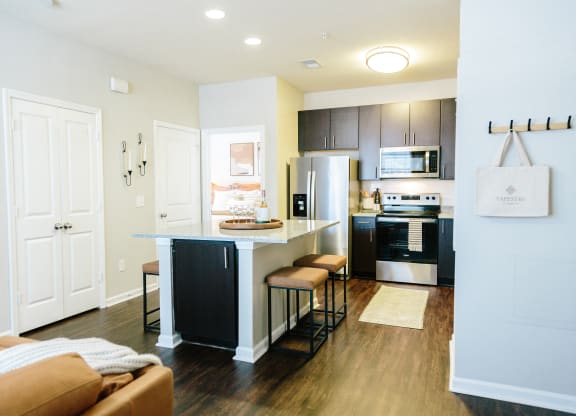 a kitchen and living room with an island and a refrigerator