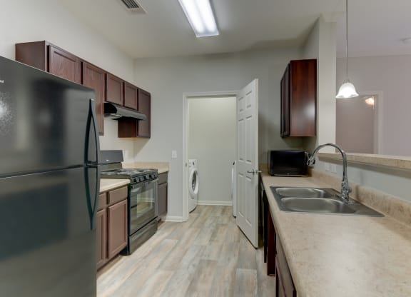 the heights at converse apartments inside of the kitchen with refrigerator and sink and cabinets
