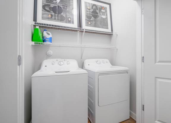 Two white front loading washing machines in a laundry room.