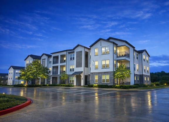 A large white building with a parking lot in front of it.