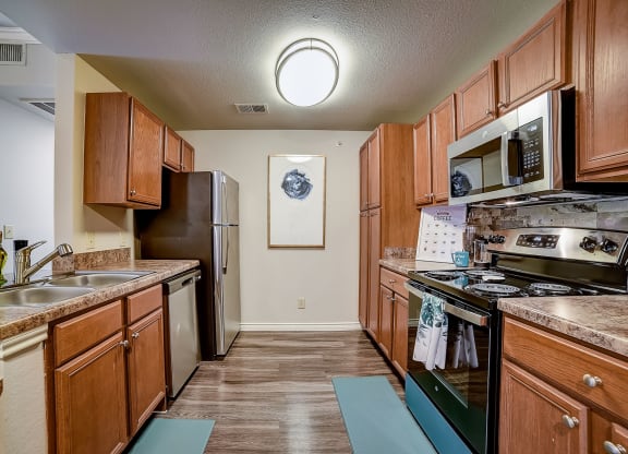 a kitchen with wood cabinets and stainless steel appliances
