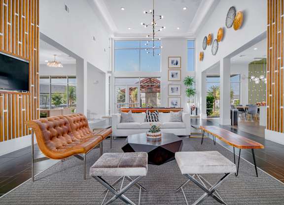 A modern living room with a brown leather sofa and a grey rug.