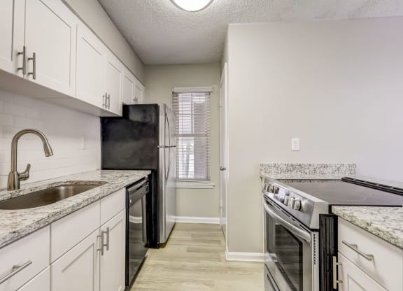 a renovated kitchen with white cabinets and a sink and a stove at Veridian