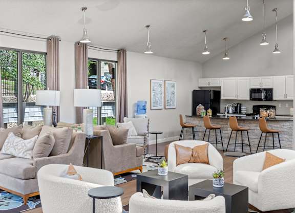 A modern living room with a kitchen in the background.