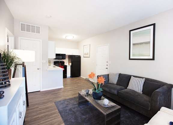 A living room with a black couch and a coffee table.
