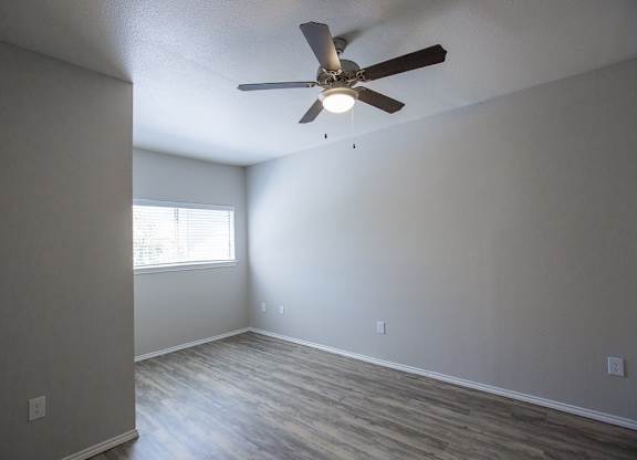 A room with a ceiling fan and a window.